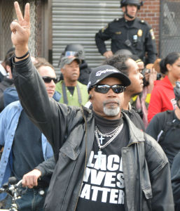 Tuesday ,April 28: Baltimore Protester Holding Up the Peace Sign (Photo Credit: Peter Langer)