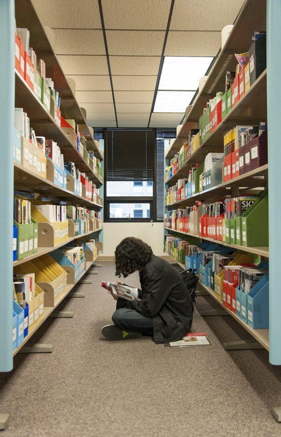 Student reads a magazine in the library. Advocate File Photo