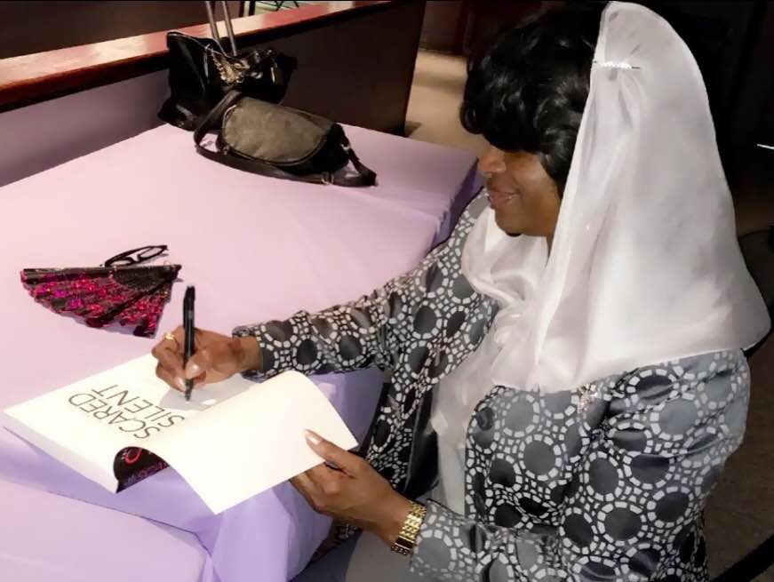 Mildred Muhammad signing her book Scared Silence (photo: Kiara Romero)