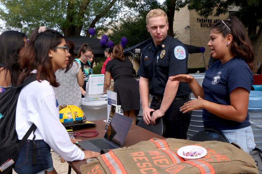 Left to right: Sasha Laredo, a pre-nursing freshman, discusses training opportunities with members of the Wheaton Volunteer Squad during the Student Life Give & Get Help Fair at Montgomery College Rockville Campus Sept. 19. The Wheaton Volunteer Squad offers free training to EMT and fire fighter volunteers.