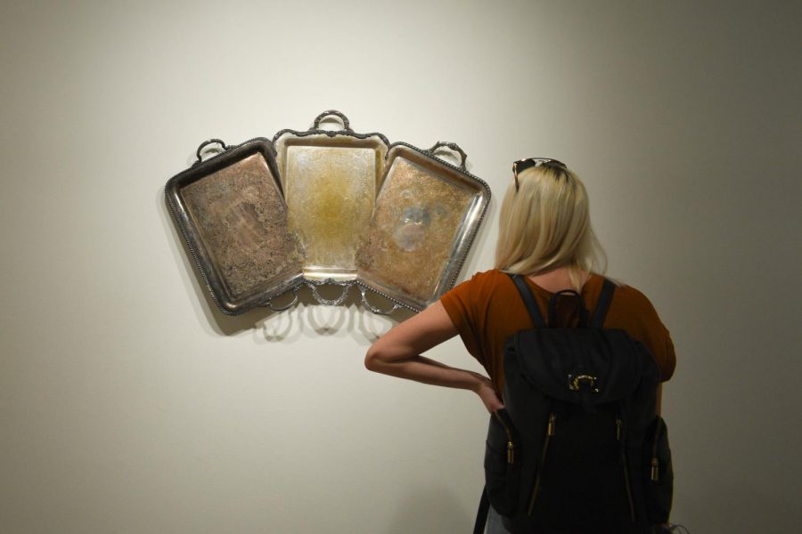 A student views one of Jaydan Moores found platter artworks.