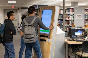 Students using the printer located in the library.