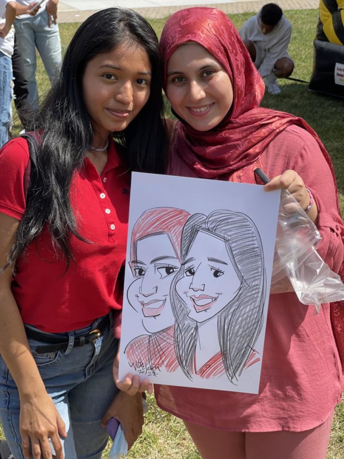 Editor in Chief of The Advocate, Ayesha Adnan and her friend Karen pose with their caricature. 
