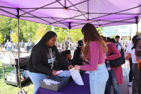 Shaw Center staff providing snacks and hand sanitizer to students and Montgomery College community members attending Club Rush.
